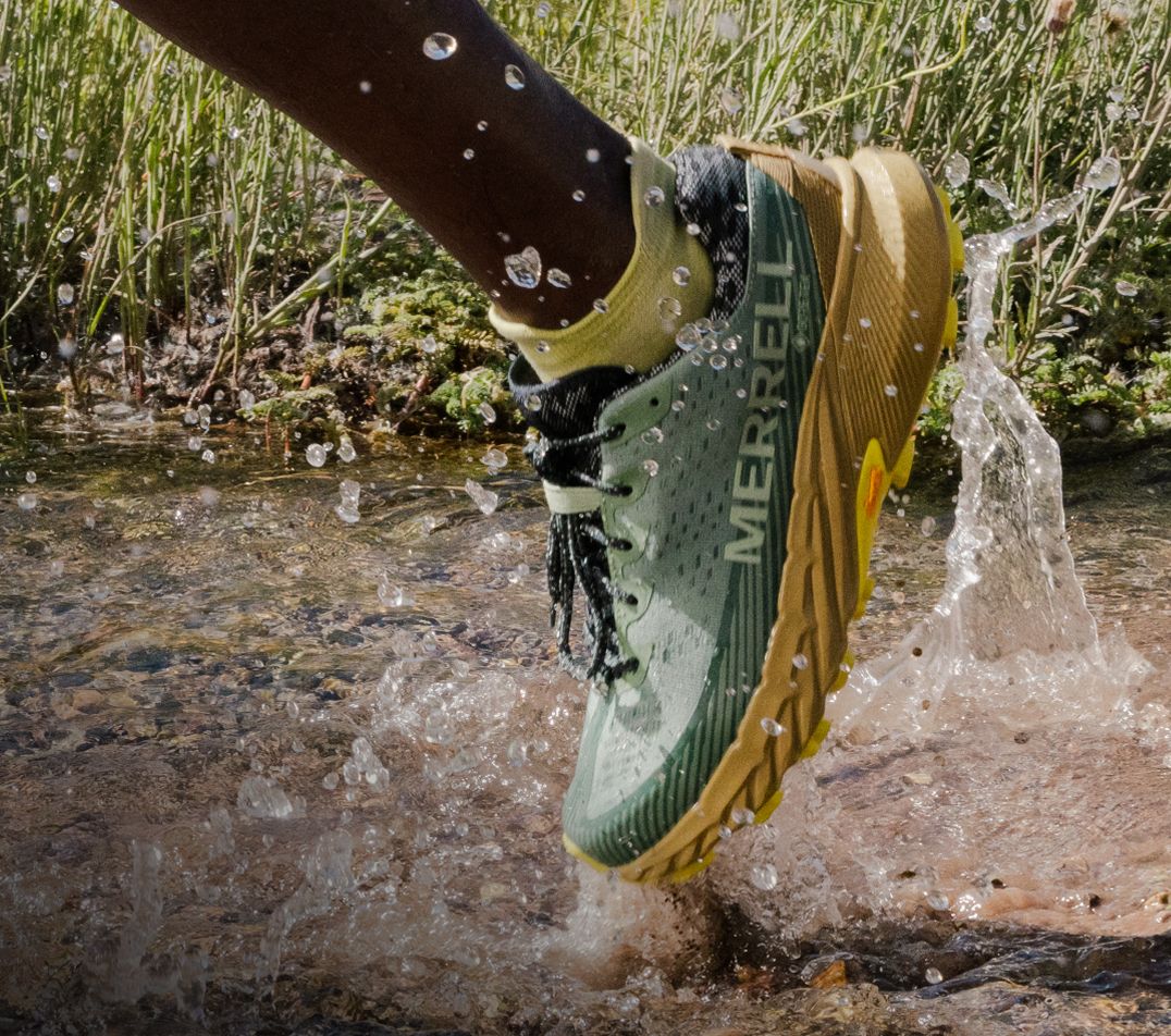 Person tying Merrell running shoes